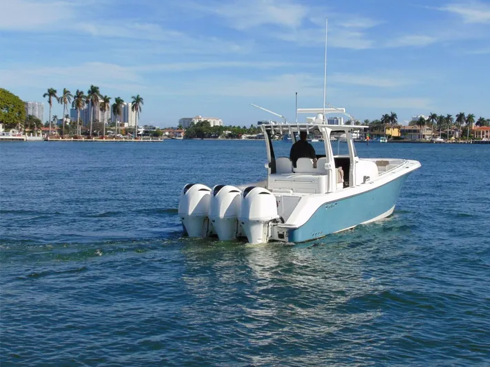  Yacht Photos Pics 2016 Edgewater 368 CC boat cruising on a sunny day with palm trees in the background.