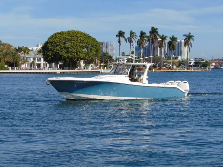  Yacht Photos Pics 2016 Edgewater 368 CC boat cruising on a sunny day with palm trees in the background.
