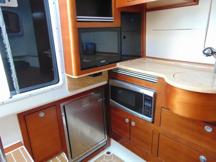  Yacht Photos Pics Interior of 2016 Edgewater 368 CC boat with wood cabinetry, microwave, and compact kitchen appliances.
