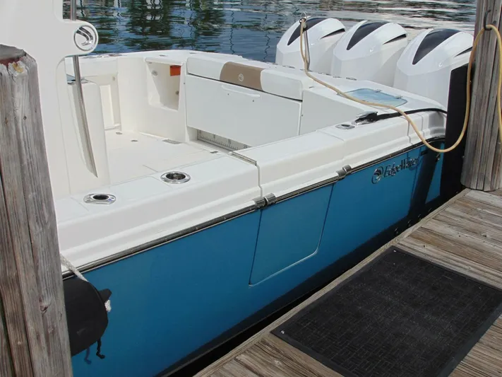  Yacht Photos Pics 2016 Edgewater 368 CC boat docked, featuring a sleek blue hull and multiple outboard engines.