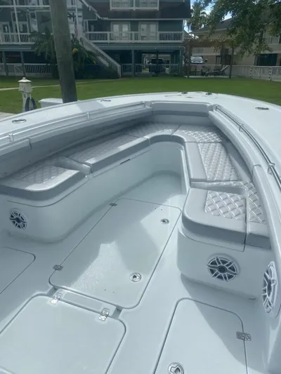 Lauren J Yacht Photos Pics 2022 Yellowfin 32 boat with cushioned seating and speakers, docked near waterfront homes.