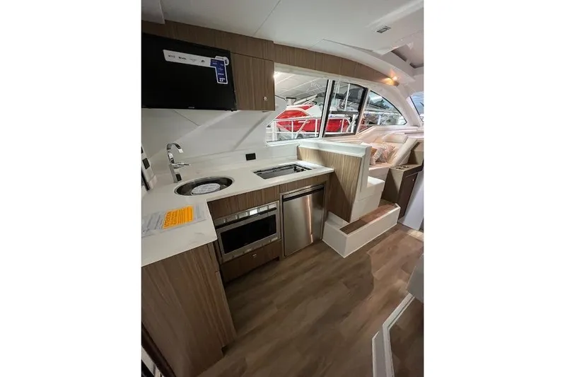  Yacht Photos Pics Modern kitchen interior of 2026 Cruisers Yachts 42 Cantius with wood finish and appliances.