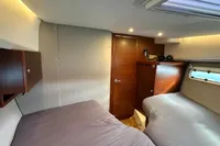 2024 Nimbus 305 Coupe cabin interior with twin beds and wooden accents.