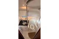 2024 Nimbus 305 Coupe bathroom with sink, toilet, and shower in compact marine design.
