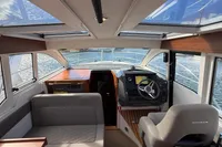Interior of 2024 Nimbus 305 Coupe, featuring modern helm and seating, with panoramic windows.
