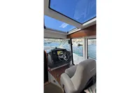 Interior view of 2024 Nimbus 305 Coupe boat cockpit with steering wheel and panoramic windows.