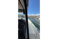 2024 Nimbus 305 Coupe navigating a marina with clear blue skies.