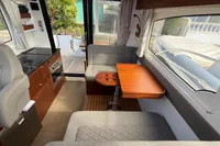 Interior of 2024 Nimbus 305 Coupe, featuring cozy seating and elegant wooden table.
