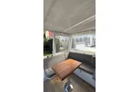 2024 Nimbus 305 Coupe interior with elegant seating and wooden table.