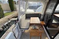 2024 Nimbus 305 Coupe boat interior with seating, table, and dock view.