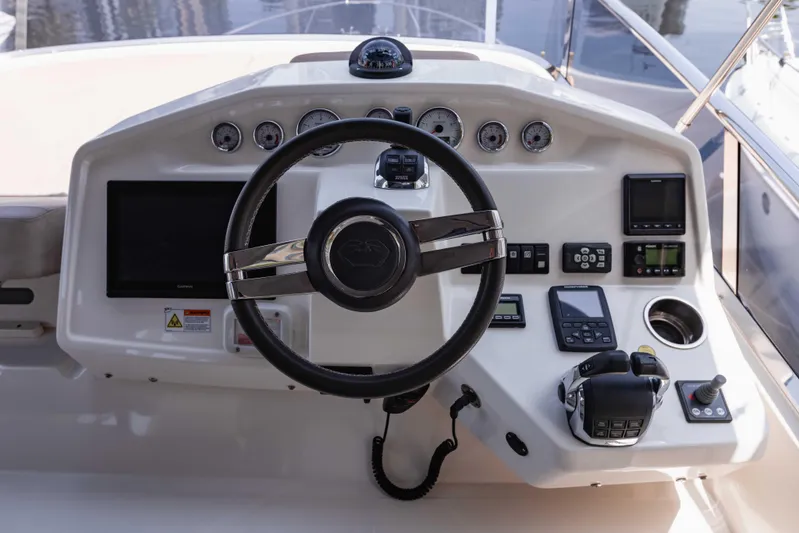  Yacht Photos Pics Control panel of 2019 Cranchi E 52F yacht with steering wheel and navigation instruments.