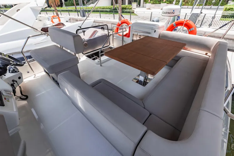  Yacht Photos Pics Luxurious seating area on 2019 Cranchi E 52F yacht with wooden table and modern design.