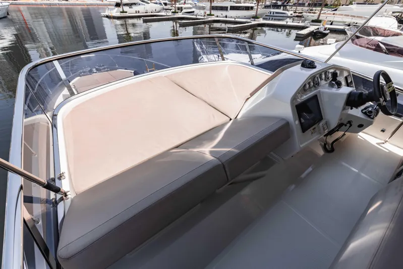  Yacht Photos Pics 2019 Cranchi E 52F yacht helm with beige seating, docked at marina.