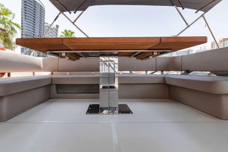  Yacht Photos Pics Luxurious seating area on 2019 Cranchi E 52F yacht with wooden table and canopy.