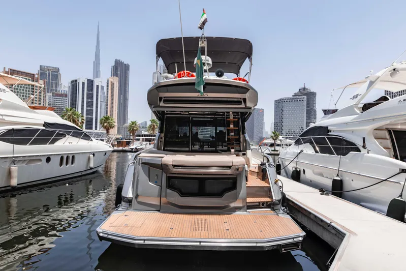 Yacht Photos Pics 2019 Cranchi E 52F yacht docked in a marina with city skyline backdrop.