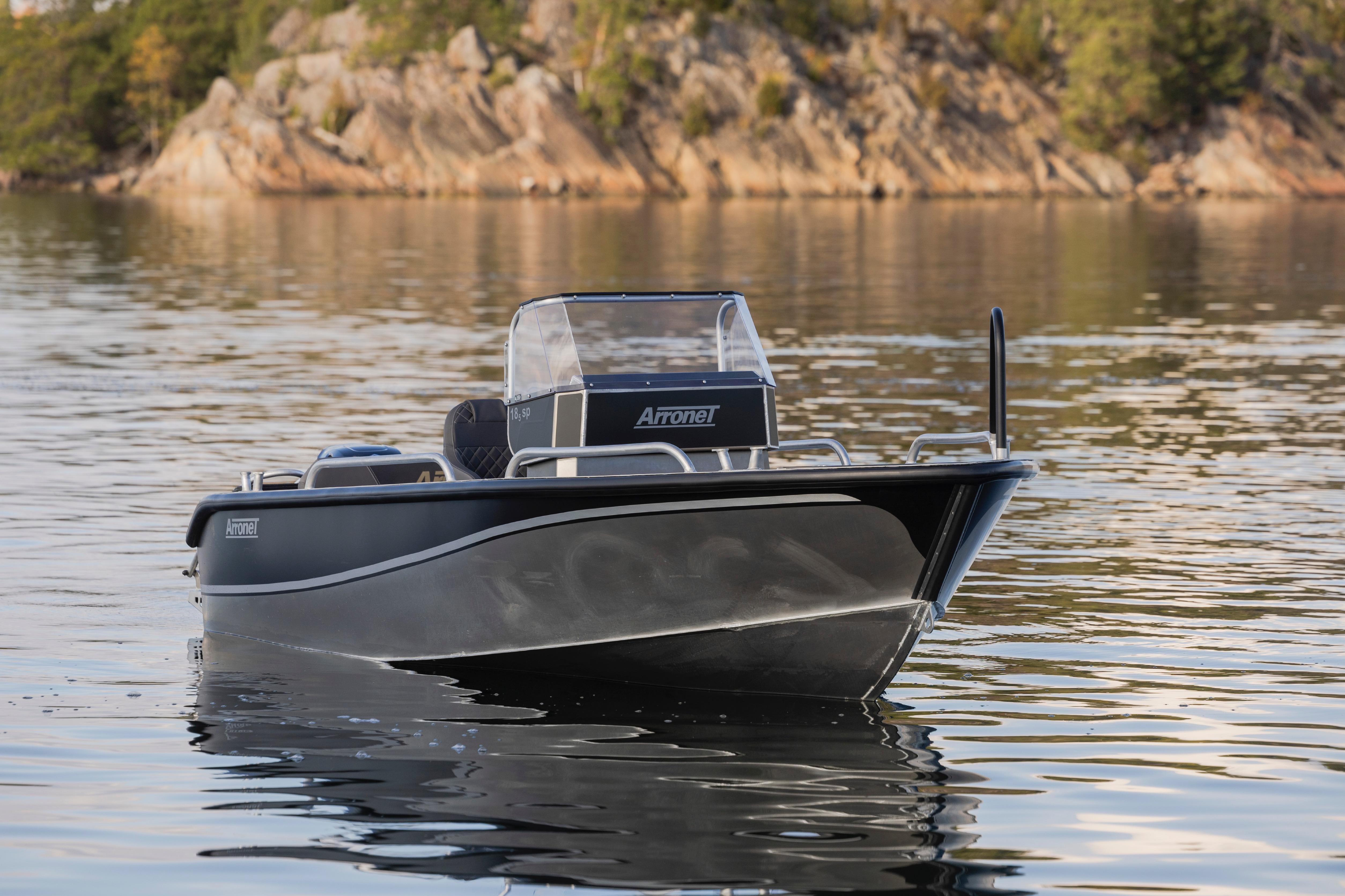2025 Arronet 18 SP boat on calm water with rocky shoreline background.