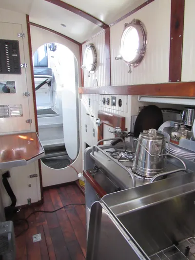 Silverado Yacht Photos Pics Interior of 2009 Custom Pilothouse Cutter with wooden flooring and compact kitchen area.