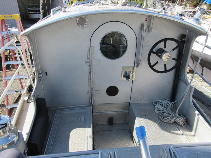 Silverado Yacht Photos Pics Custom 2009 Pilothouse Cutter cockpit with wheel, ropes, and metal door.