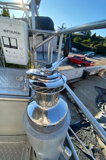 Silverado Yacht Photos Pics Stainless steel winch on 2009 Custom Pilothouse Cutter, docked with vehicles in background.