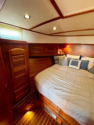 Serendipity II Yacht Photos Pics Cozy bedroom interior of 2010 Sabre 40 Sedan yacht with wood accents and soft lighting.