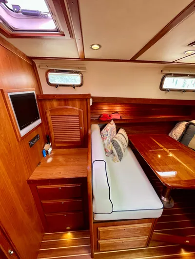 Serendipity II Yacht Photos Pics 2010 Sabre 40 Sedan interior with wooden cabinetry, cushioned seating, and a mounted TV.