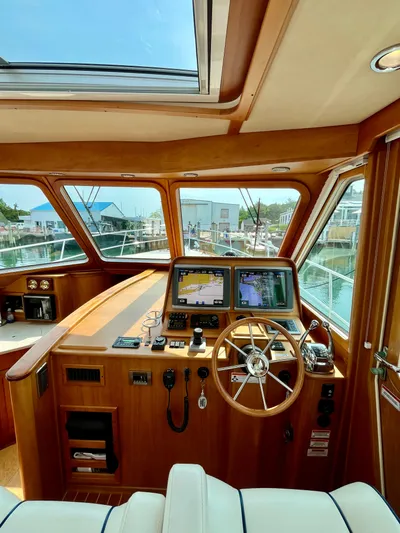 Serendipity II Yacht Photos Pics Interior of 2010 Sabre 40 Sedan yacht with navigation equipment and wooden steering wheel.