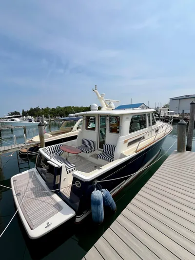 Serendipity II Yacht Photos Pics 2010 Sabre 40 Sedan yacht docked at marina with striped seating and clear skies.