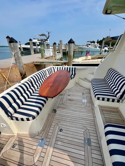 Serendipity II Yacht Photos Pics 2010 Sabre 40 Sedan yacht with striped seating and wooden table at a marina.