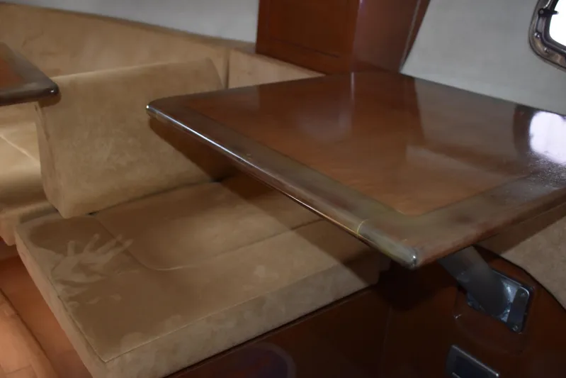 Windy Gale IV Yacht Photos Pics Interior of 2011 Sea Ray 310 Sundancer with wooden table and beige seating.