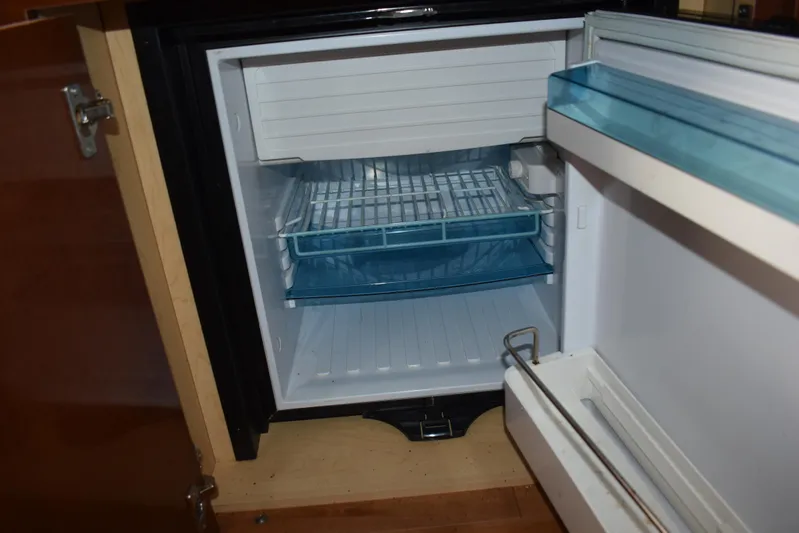 Windy Gale IV Yacht Photos Pics Open refrigerator inside a 2011 Sea Ray 310 Sundancer boat, showing empty shelves.