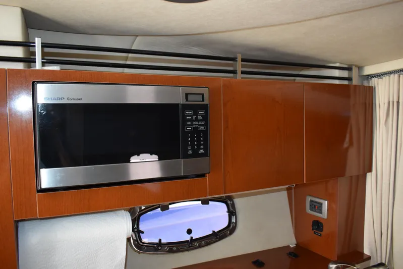 Windy Gale IV Yacht Photos Pics Interior of 2011 Sea Ray 310 Sundancer with microwave and wooden cabinetry.