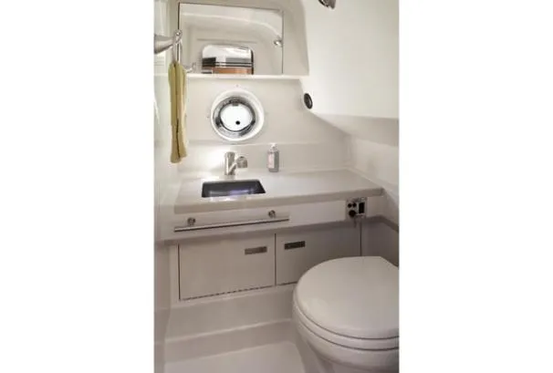Windy Gale IV Yacht Photos Pics 2011 Sea Ray 310 Sundancer bathroom with sink, mirror, and porthole window.