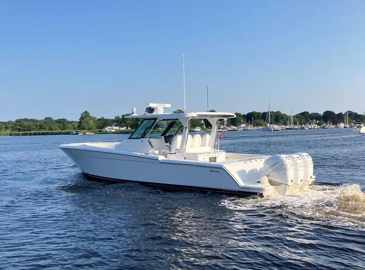  Yacht Photos Pics 2022 Bertram 39 CC boat cruising on a calm lake with clear skies.