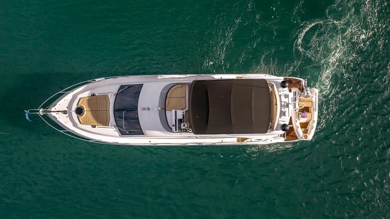 Cloud Catcher Yacht Photos Pics Aerial view of 2014 Sunseeker Manhattan 55 yacht cruising on clear blue water.