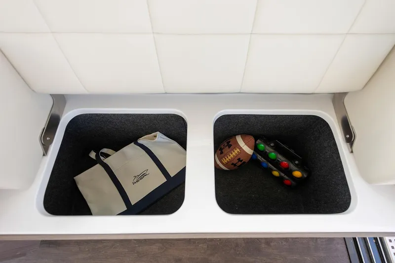  Yacht Photos Pics Manufacturer Provided Image: Storage compartments on a 2025 Regal 38 FXO boat with bag and sports items.