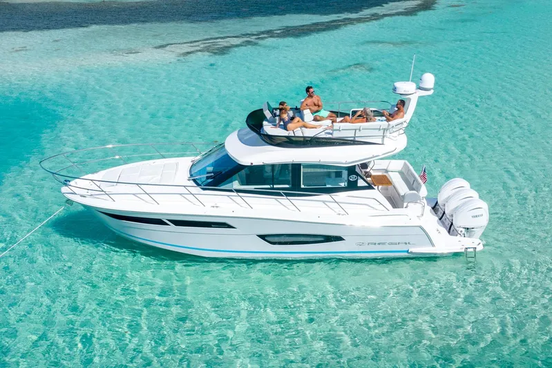  Yacht Photos Pics Manufacturer Provided Image: 2025 Regal 38 FXO yacht cruising in clear turquoise waters with passengers relaxing on deck.