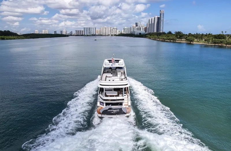 Gold Star Yacht Photos Pics Galeon 640 Fly 2020 yacht cruising on a scenic waterway with city skyline.