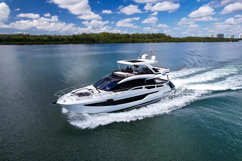 Gold Star Yacht Photos Pics 2020 Galeon 640 Fly yacht cruising on a serene lake under a blue sky.
