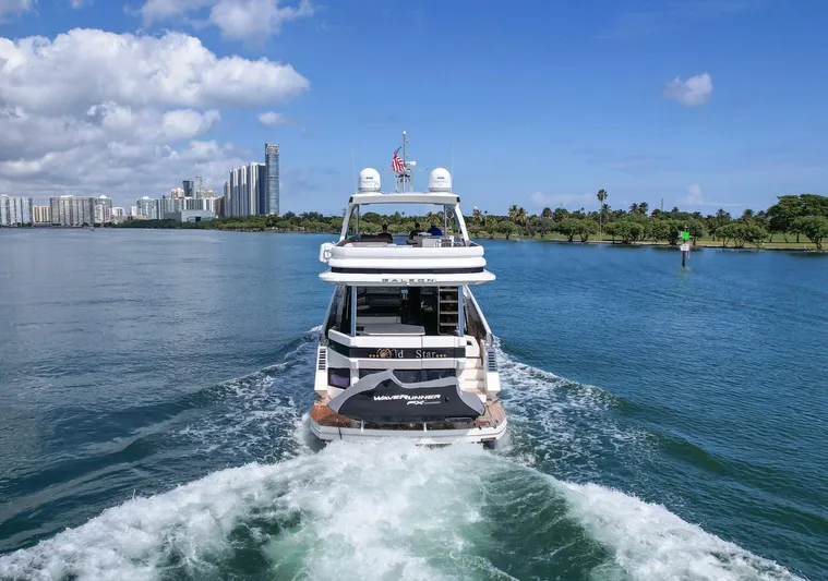 Gold Star Yacht Photos Pics Galeon 640 Fly yacht cruising in scenic waters, city skyline in background, 2020 model.