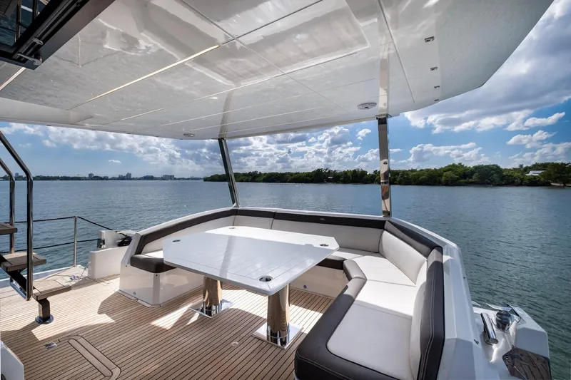Gold Star Yacht Photos Pics Luxurious 2020 Galeon 640 Fly yacht deck with seating and table, overlooking serene water.