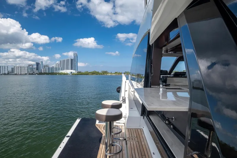 Gold Star Yacht Photos Pics Luxury Galeon 640 Fly yacht with city skyline, 2020 model, docked on calm water.