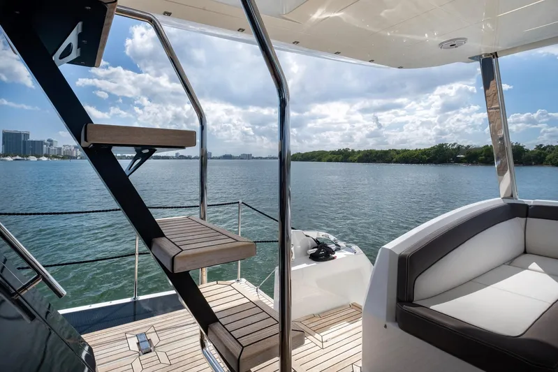 Gold Star Yacht Photos Pics Luxurious Galeon 640 Fly yacht deck with stairs, overlooking serene water and skyline.