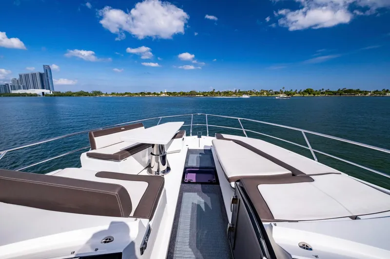 Gold Star Yacht Photos Pics Luxurious 2020 Galeon 640 Fly yacht deck with seating, overlooking serene water and cityscape.