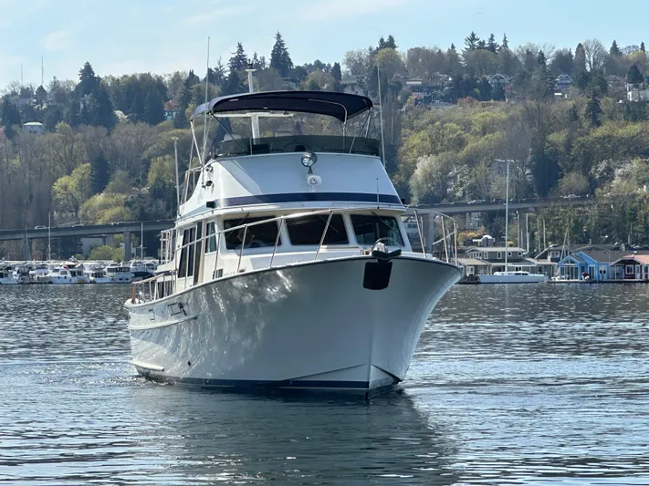  Yacht Photos Pics 1982 Tollycraft Tri Cabin yacht cruising on a calm lake with scenic forested hills.