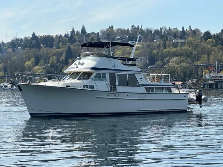  Yacht Photos Pics 1982 Tollycraft Tri Cabin yacht on calm water with scenic forested background.