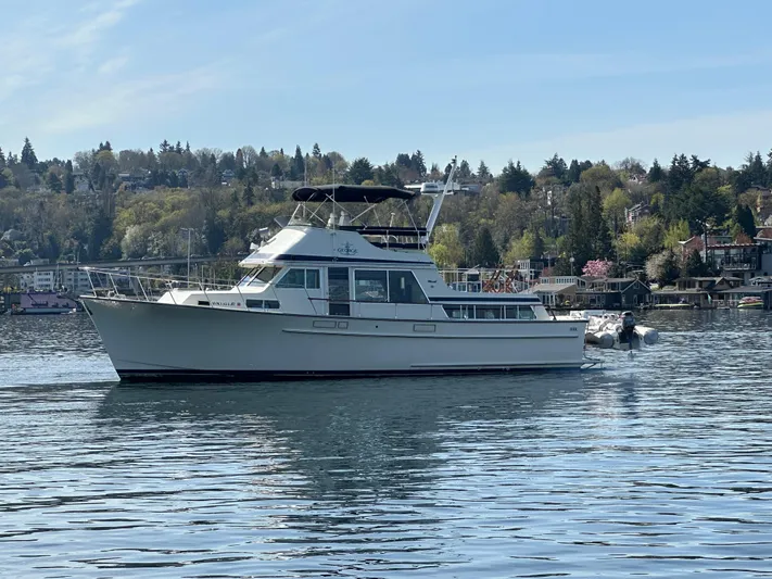  Yacht Photos Pics 1982 Tollycraft Tri Cabin boat on a calm lake with scenic background.