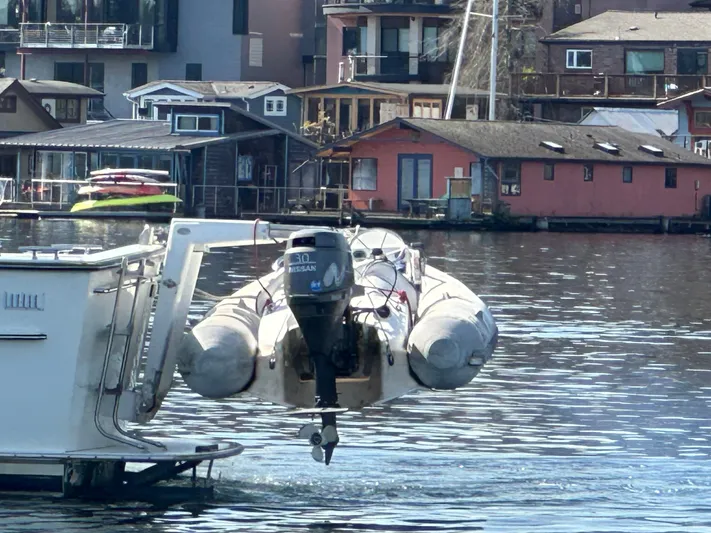  Yacht Photos Pics 1982 Tollycraft Tri Cabin with dinghy, docked near waterfront homes.