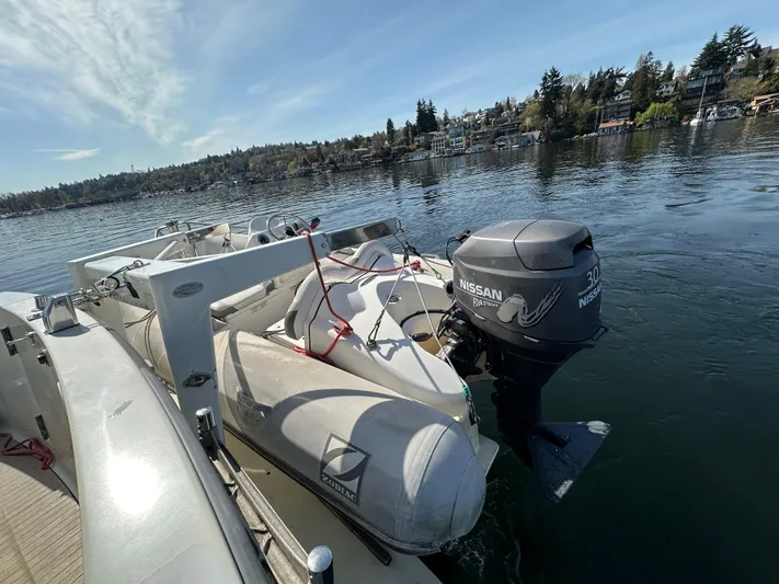  Yacht Photos Pics 1982 Tollycraft Tri Cabin with dinghy and Nissan outboard motor on a calm lake.