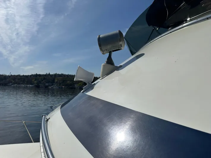  Yacht Photos Pics 1982 Tollycraft Tri Cabin boat with spotlight and horn on deck, under clear blue sky.