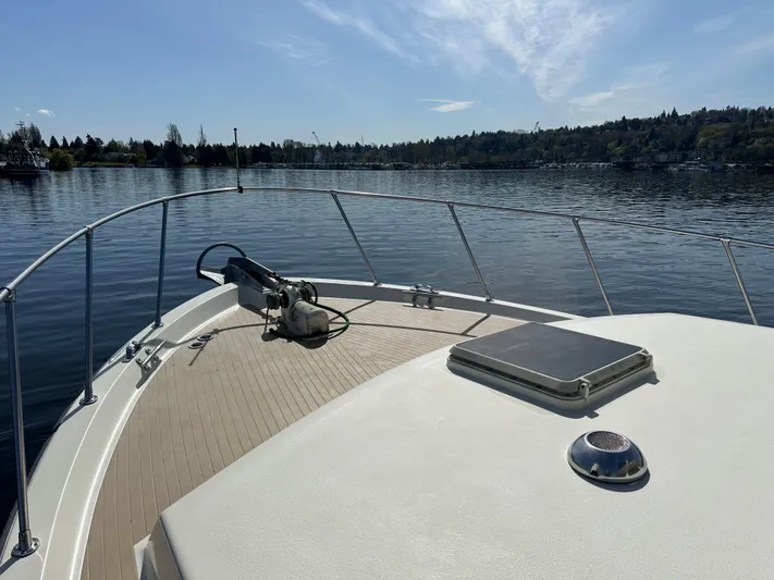  Yacht Photos Pics 1982 Tollycraft Tri Cabin boat on calm lake with clear sky and distant shoreline.